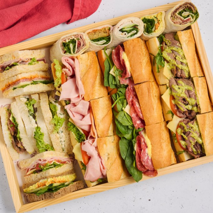 A mixed bread platter of point sandwiches, wraps and baguettes